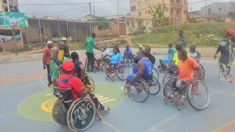 Échauffement : des dizaines de joueurs en fauteuil se déplacent ensemble au centre du terrain.