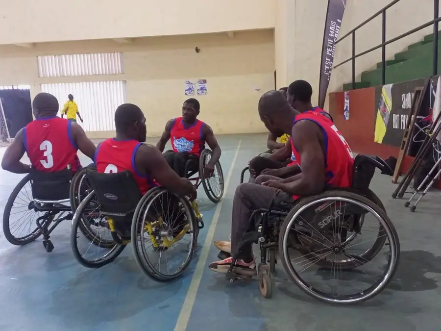 Une équipe en maillots rouges se regroupe en fauteuil pendant un temps mort.